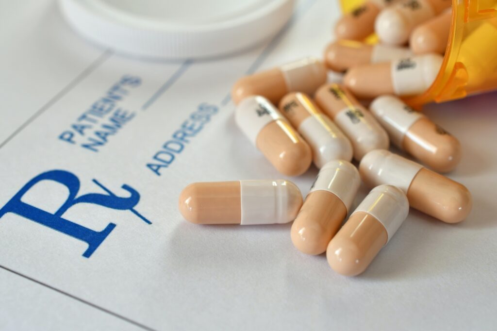 Capsule pills medicine pharmaceutical drugs laying on a prescription RX pad