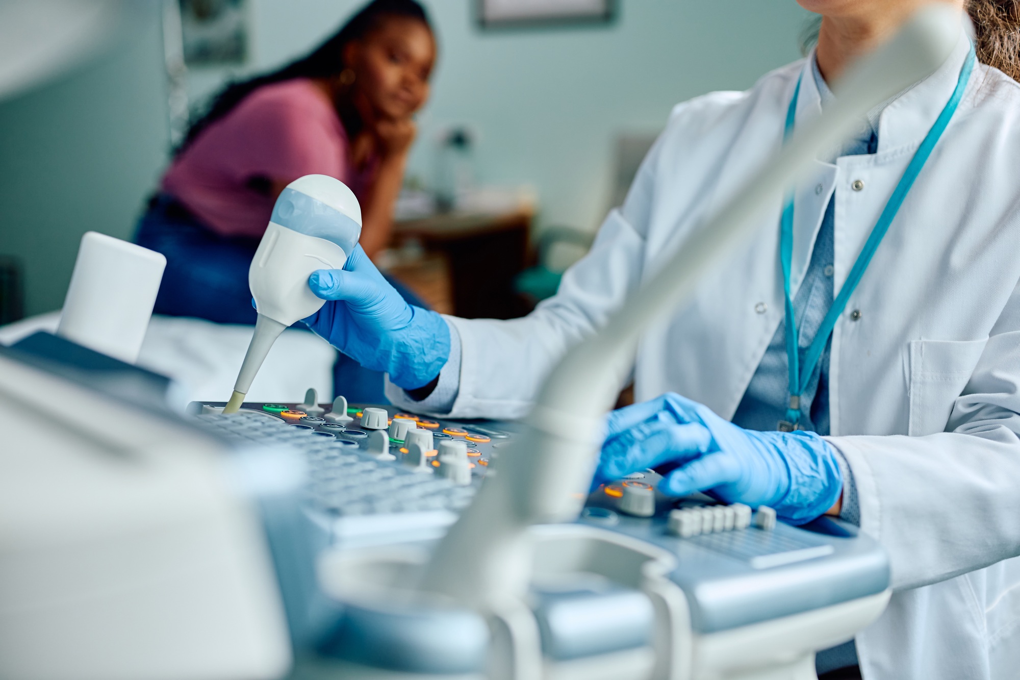 Close up of doctor using ultrasound in medical examination room.