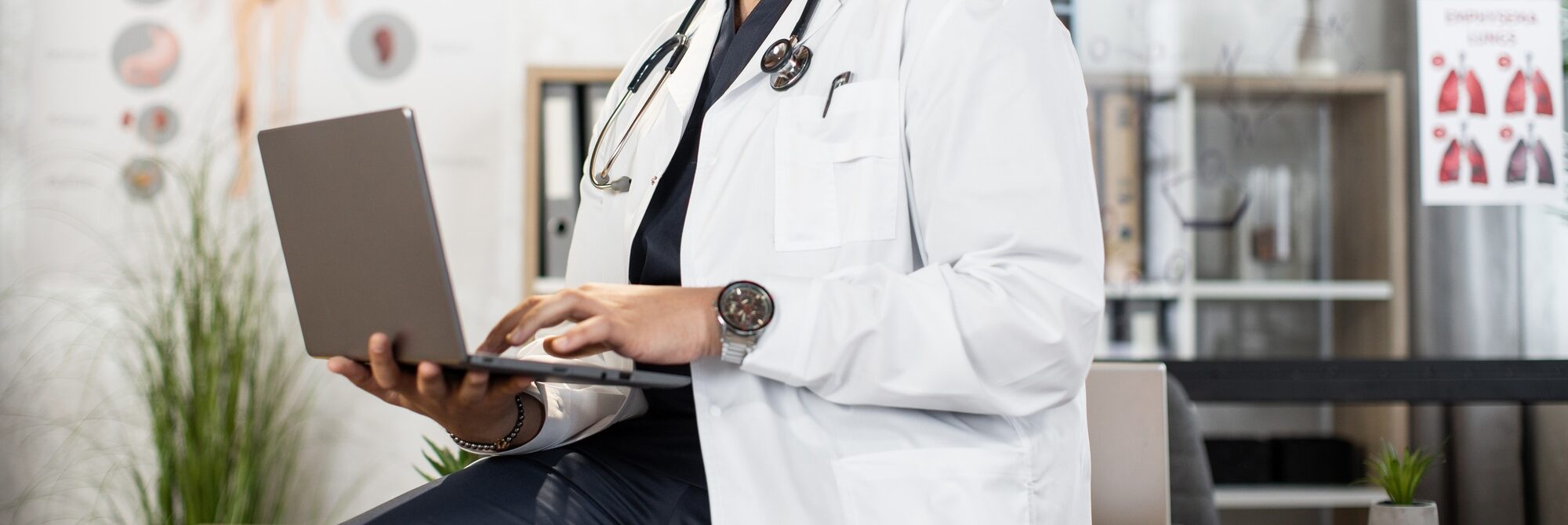 Professional medical specialist using laptop at work